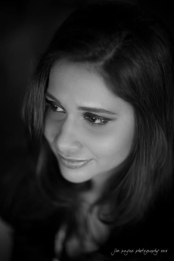 unc chapel hill engagement session ~ thelsa and phil Black and white portrait of a woman gazing to the side with a subtle smile. She has long hair and is wearing makeup. The background is softly blurred.