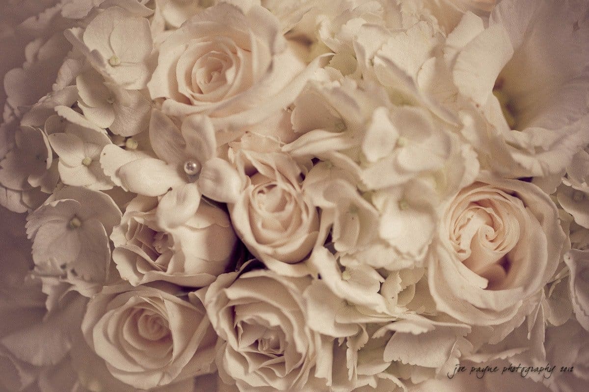A close-up of a bouquet featuring pale pink roses and white hydrangeas, creating a soft, romantic floral arrangement.