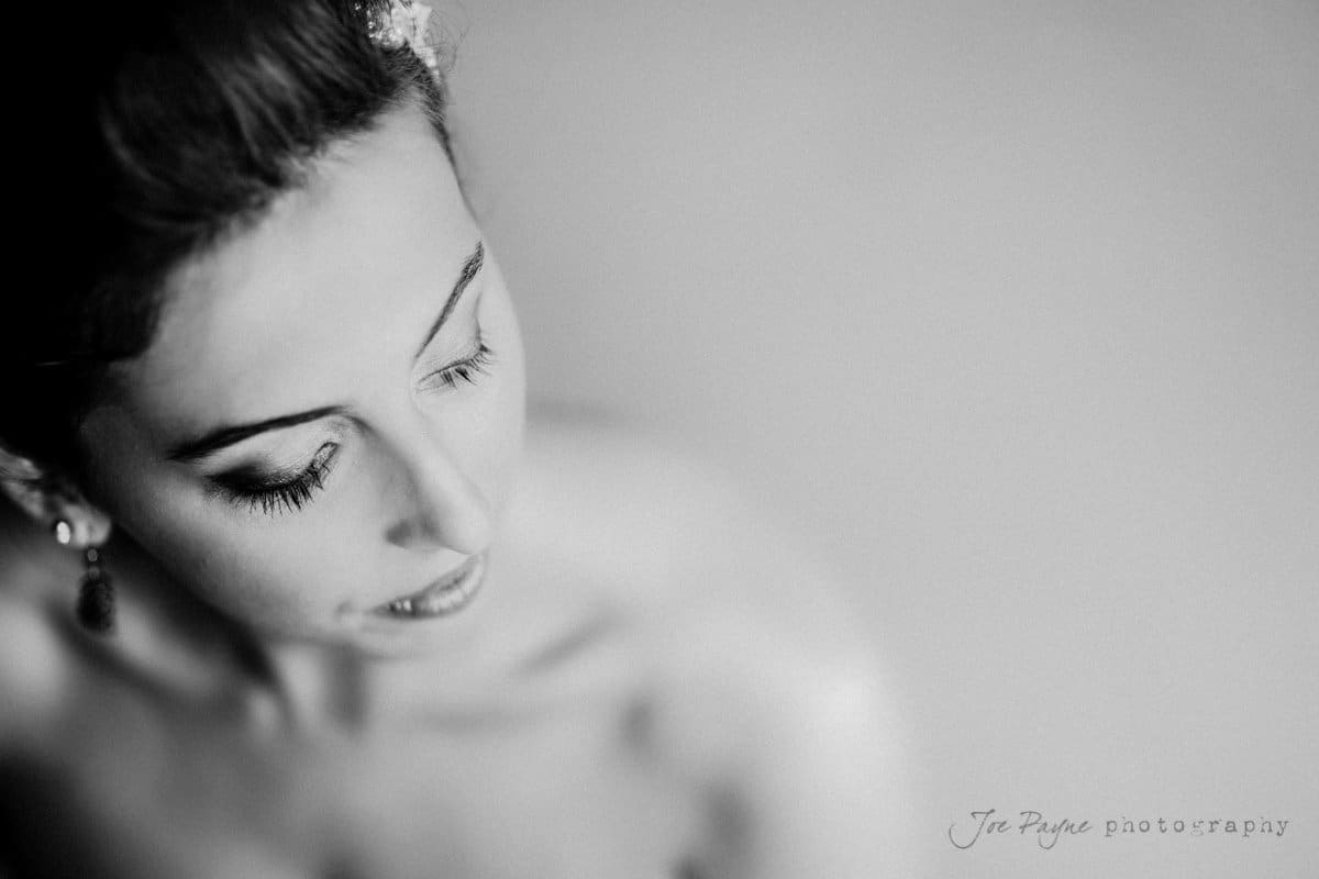 Black and white portrait of a woman with closed eyes, viewed from above and slightly to the side. She seems to be in a calm, reflective moment, with soft lighting enhancing her features.