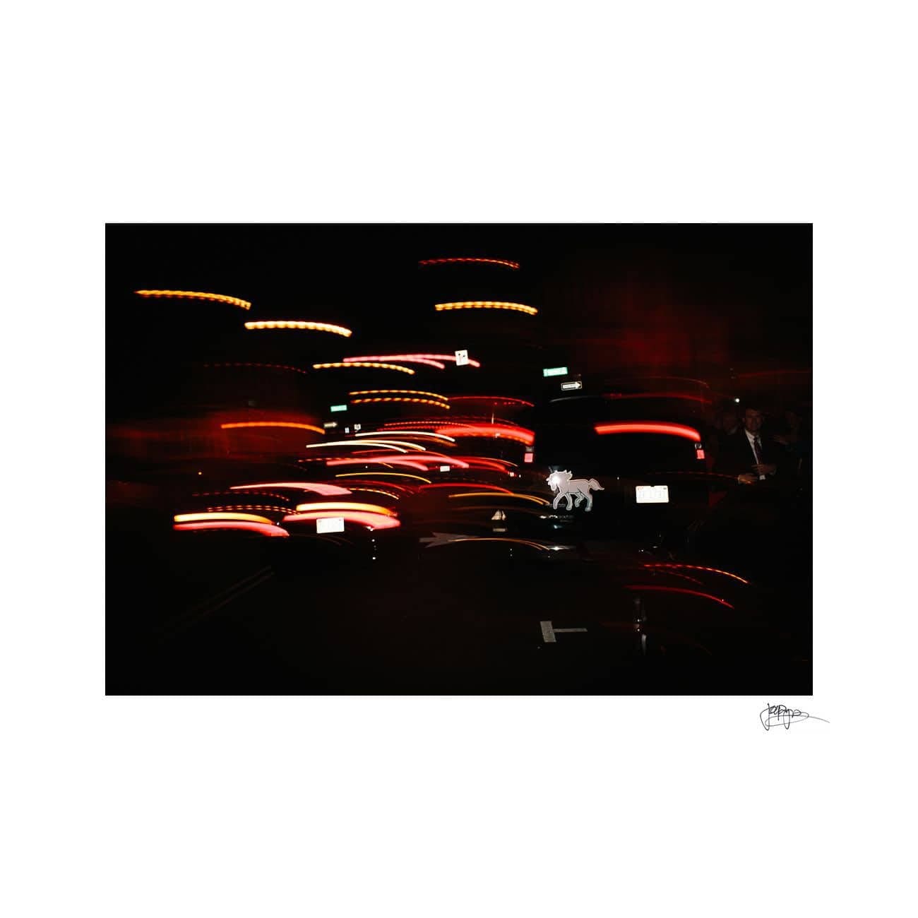Blurred lights in a dark setting create dynamic streaks of red and white, resembling car lights at night. The motion effect suggests a bustling urban scene.