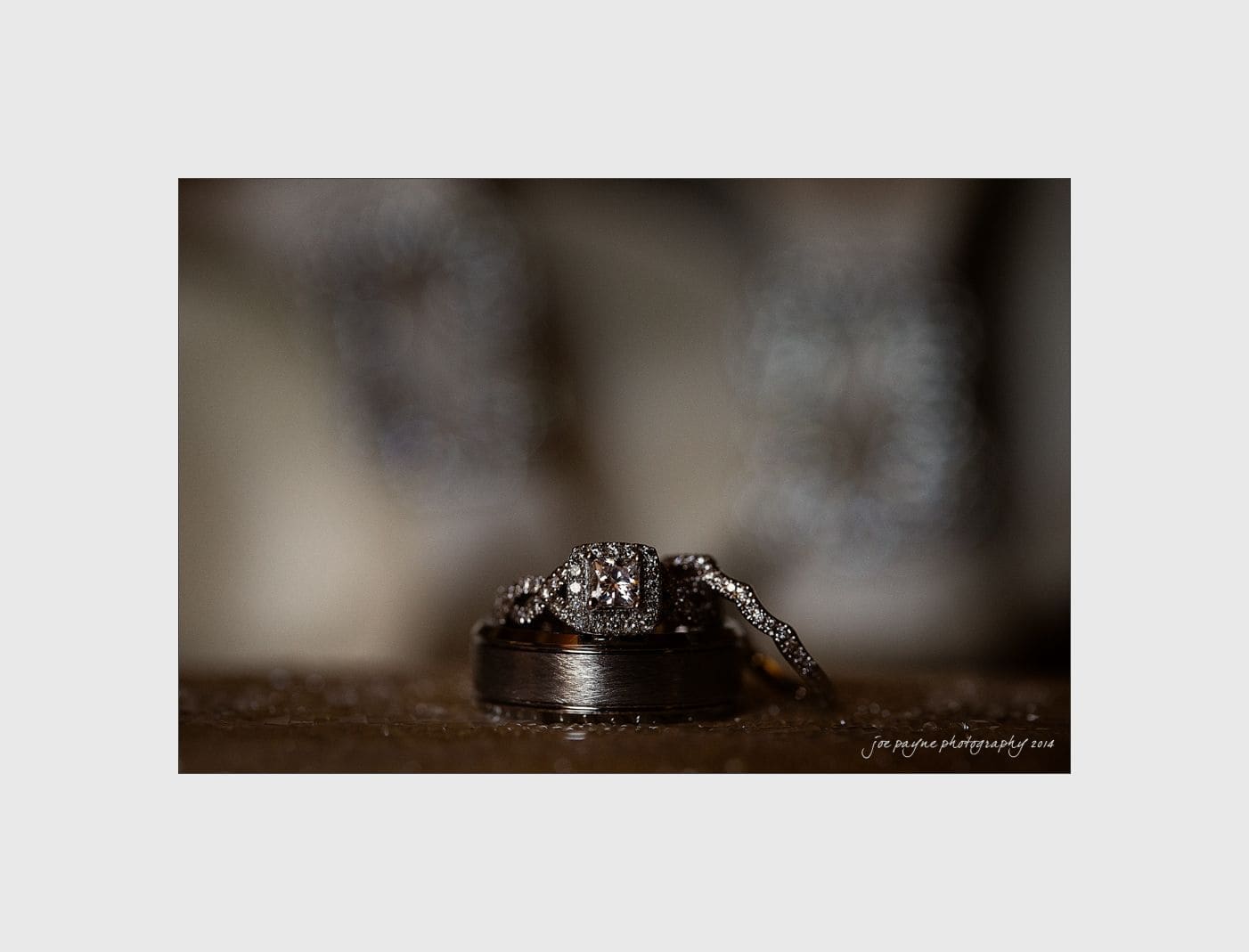 wilmington wedding photographer - nichole & eric Close-up of a sparkling diamond engagement ring with a matching wedding band placed on a reflective surface, creating an elegant and luxurious display.