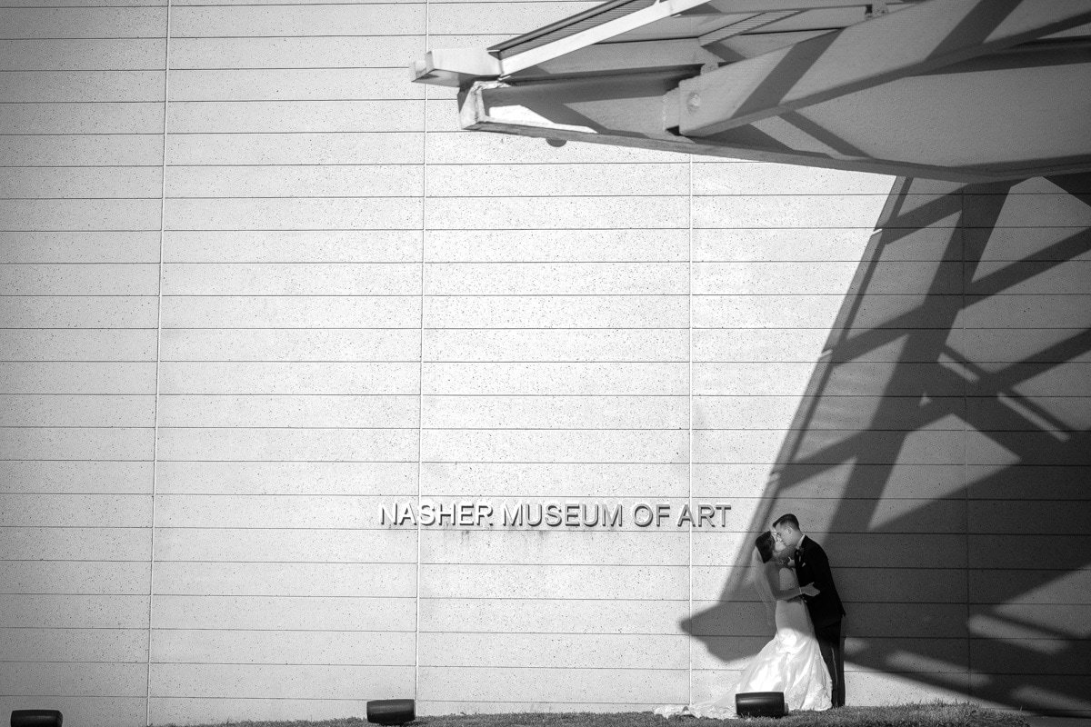 Wedding portrait of newlyweds outside Nasher Museum in Durham, NC incorporating shadows from the structure's architecture