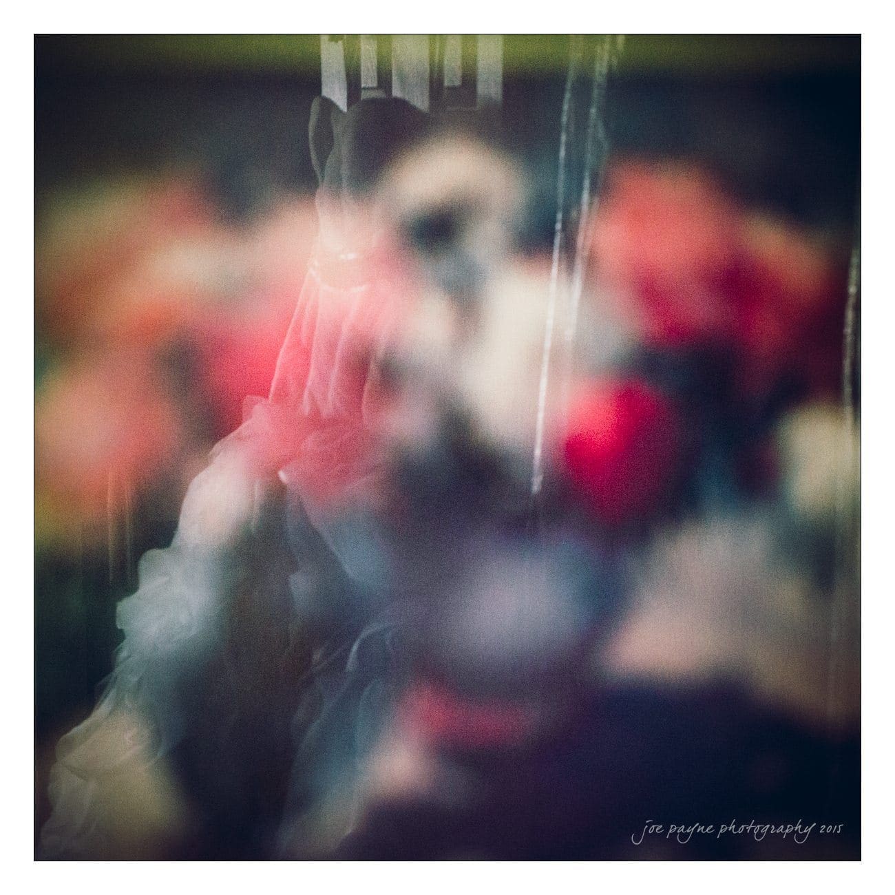 A blurred and abstract image with soft, overlapping shapes and colors, including reds and blues, creating a dreamy effect.