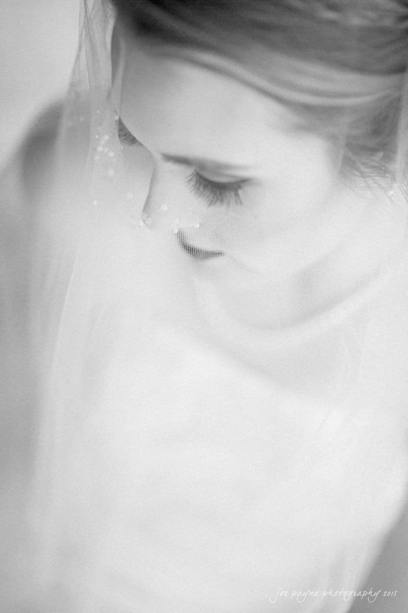 charlotte wedding photographers - ashley & matt Black and white portrait of a bride with closed eyes, wearing a veil. The image focuses on her serene expression and delicate features, highlighting her eyelashes and softly blurred details.