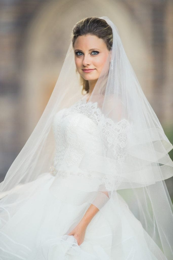A fine art bridal portrait of Sara taken outside Duke Chapel, utilizing a 200mm telephoto lens for beautiful background compression against the grand stone architecture.