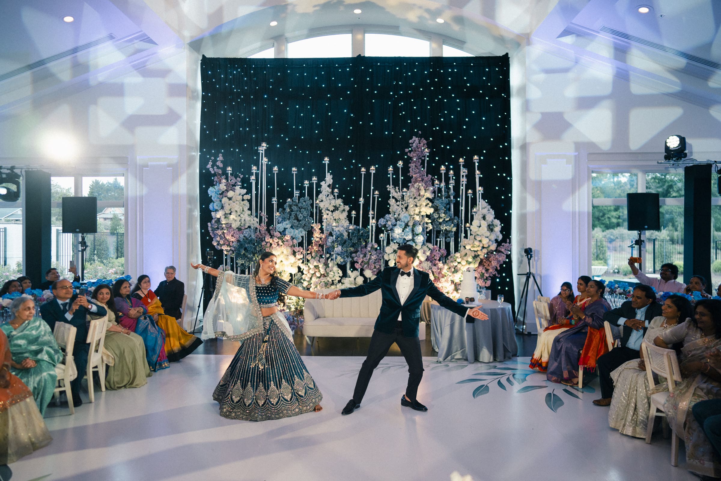 A bride and groom smile joyfully while performing a synchronized dance routine for their guests at a luxury Donovan Manor wedding reception.