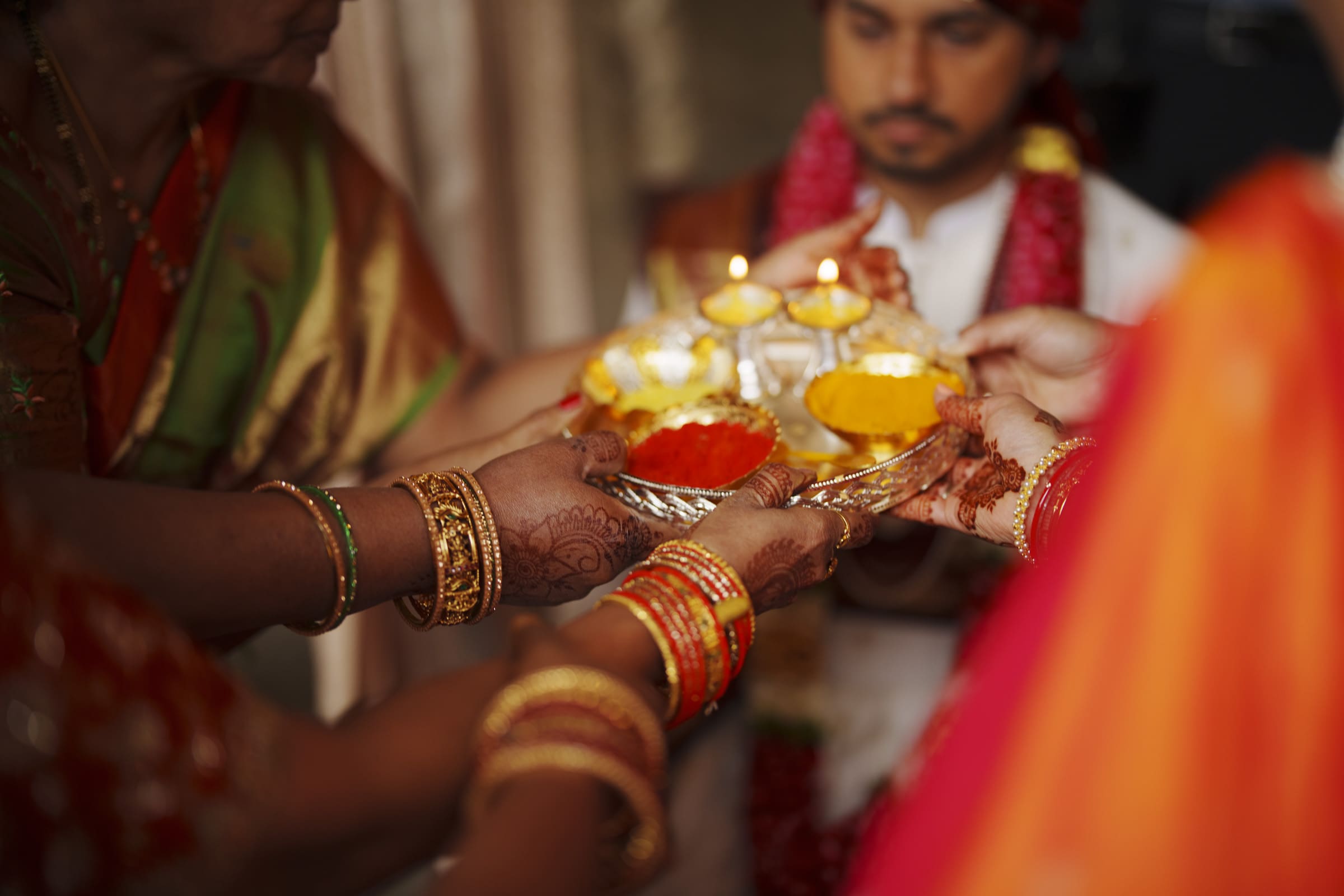 Family members hold a decorated thali with ceremonial lamps during a traditional South Indian wedding ceremony at The Pavilion at Carriage Farm.