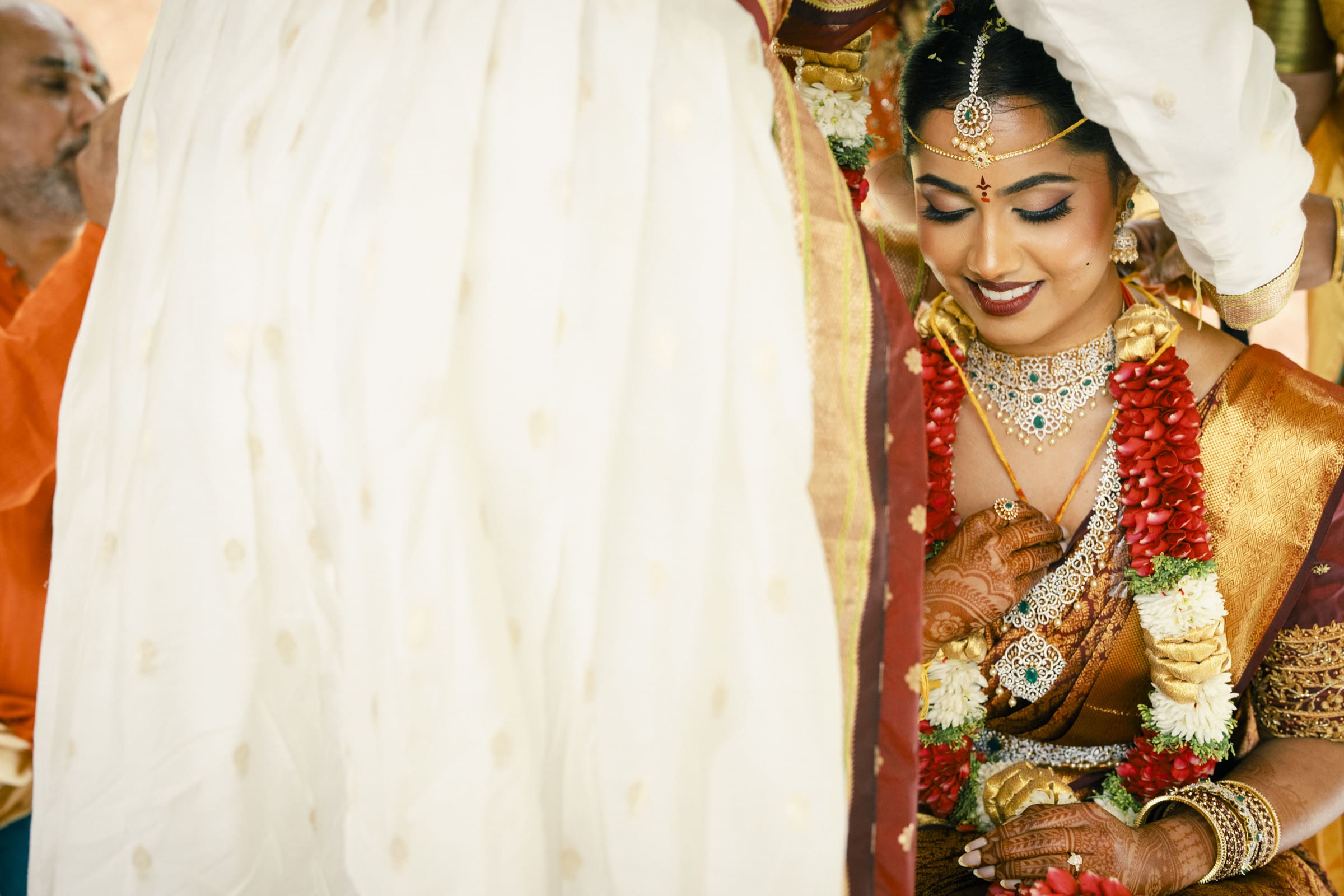 A stunning bridal portrait of a South Indian bride partially covered by a ceremonial veil during her wedding at The Pavilion at Carriage Farm.