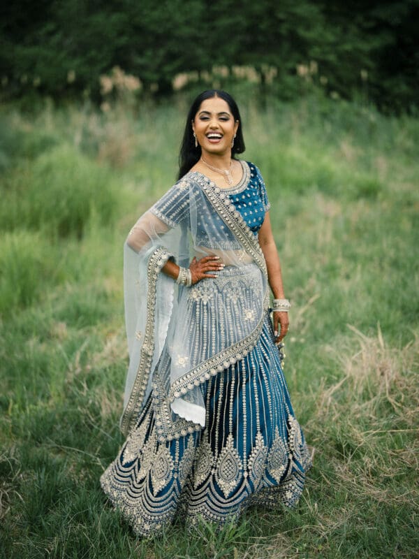 A stunning full-length bridal portrait of an Indian bride displaying her intricate blue and silver embroidered lehenga at Donovan Manor.
